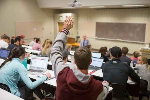 Student raising their hand in a classroom