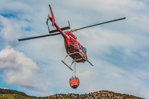 elicottero rosso che trasporta acqua