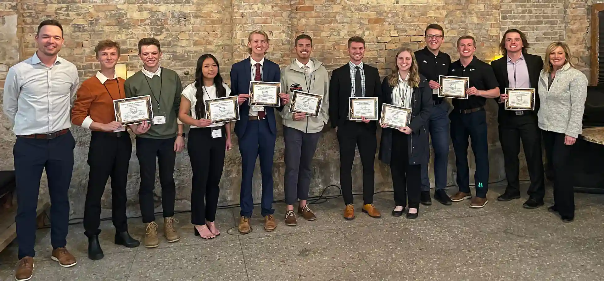 2023 S4 competition winners standing against a brick wall with their awards and the program directors