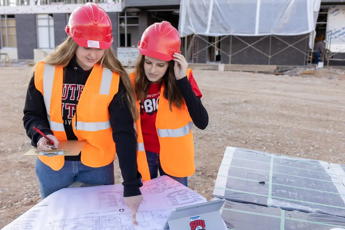 Southern Utah University students studying blueprints at a job site for the Civil Engineering Bachelors degree.