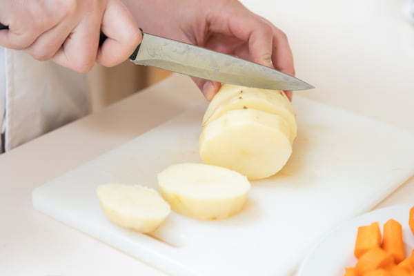 A SUU student cutting a potato for the human nutrition bachelors degree program.