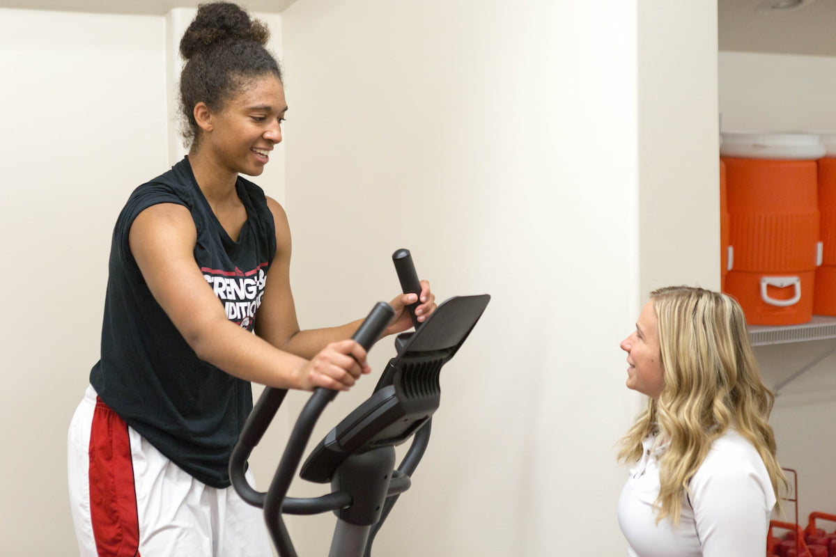 Southern Utah University physical education student on elliptical with educator for the Bachelors degree program.