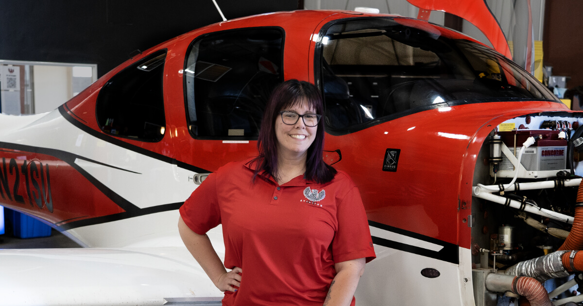 Amelia Willden stands in front of a small SUU aircraft