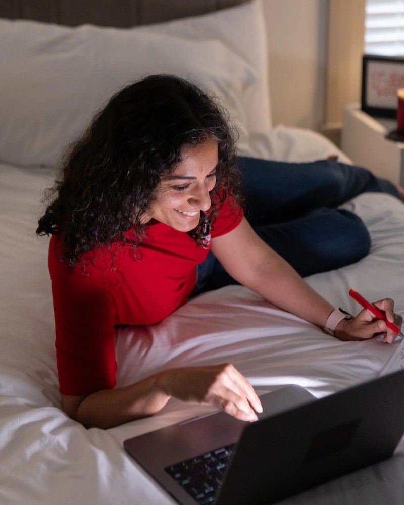 A woman looking at laptop earning their online degree from SUU online program.