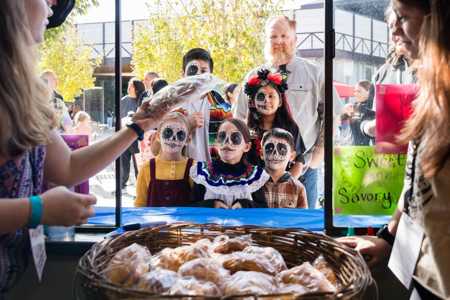 Family receiving pan de muerto at Day of the Dead.